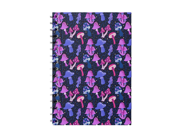 Photo shows a notebook on a white backgrond. The notebook has hand illustrated mushrooms in a variety of types and shades of pink, fushia, lavender, and indigo. It is set on a dark blue background with vines of leafs intertwined. There are magical twinkle stars scattered about for a real enchanted forest feel. A gorgeous piece of magical, bohemian, stationery.